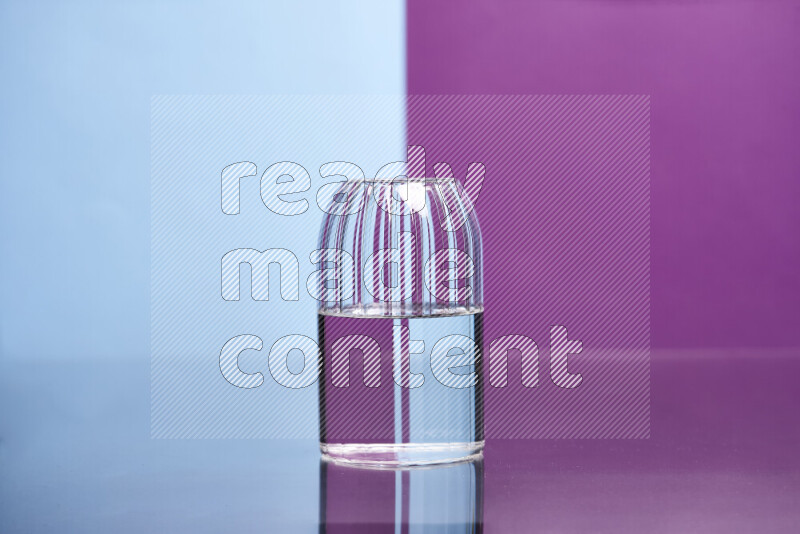 The image features a clear glassware filled with water, set against light blue and purple background