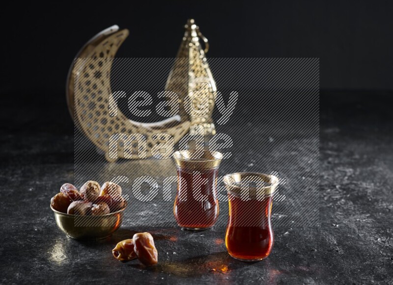 تمر مع مشروبات ساخنة وفوانيس ذهبية علي خلفية سوداء خشبية