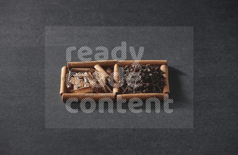 2 squares of cinnamon sticks full of cloves and cinnamon on black flooring