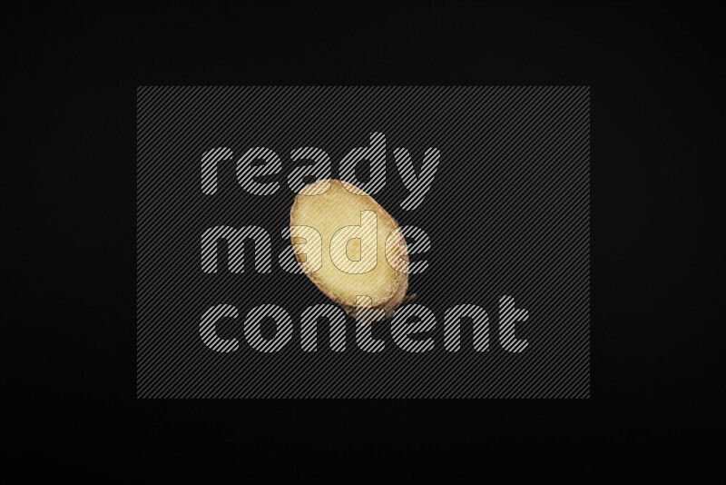 Fresh ginger slices on black background