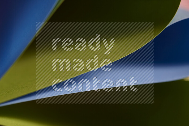 An abstract art showing blue and green paper sheets arranged in an overlapping curves