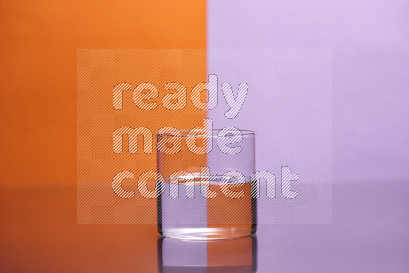The image features a clear glassware filled with water, set against orange and light purple background
