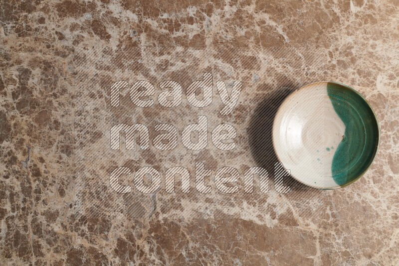 A decorative pottery plate on beige marble background