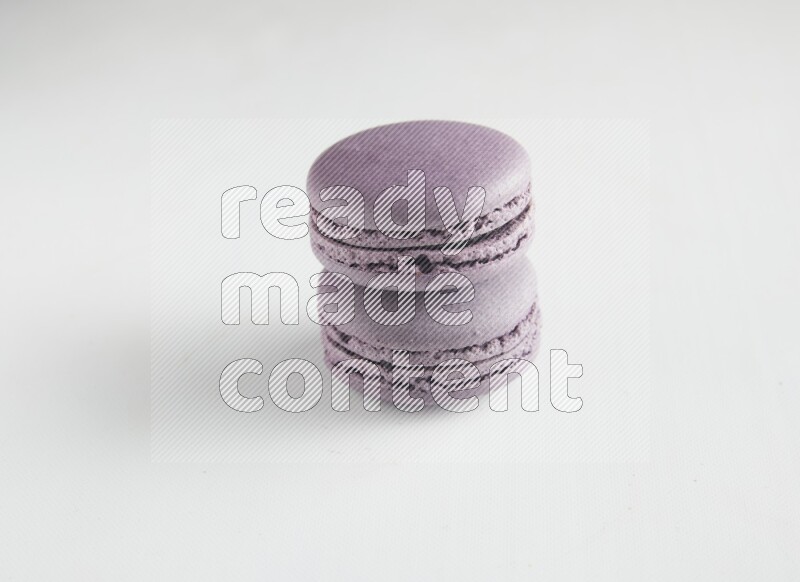 45º Shot of two Purple Blueberry macarons on white background
