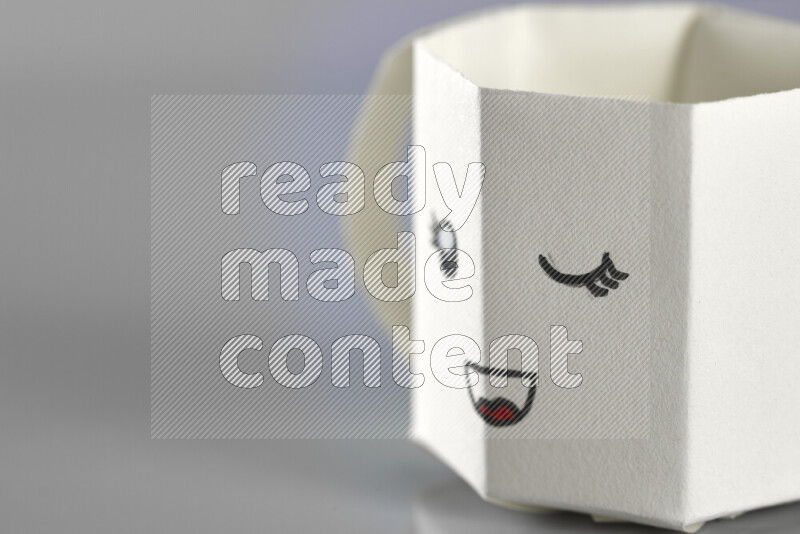 Origami cup on grey background