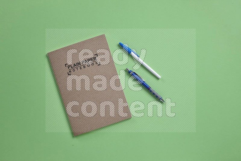 A notebook with school supplies on green background (Back to school)