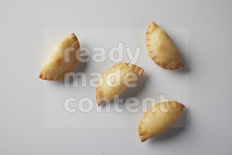 Four fried sambosa from a top angle on a white background