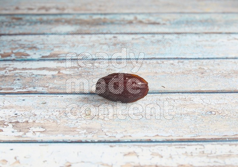 one madjoul date on a light blue wooden background