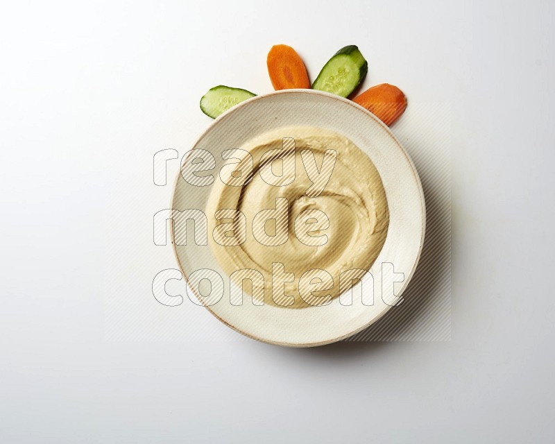 plain Hummus in a pottry plate  on a white background