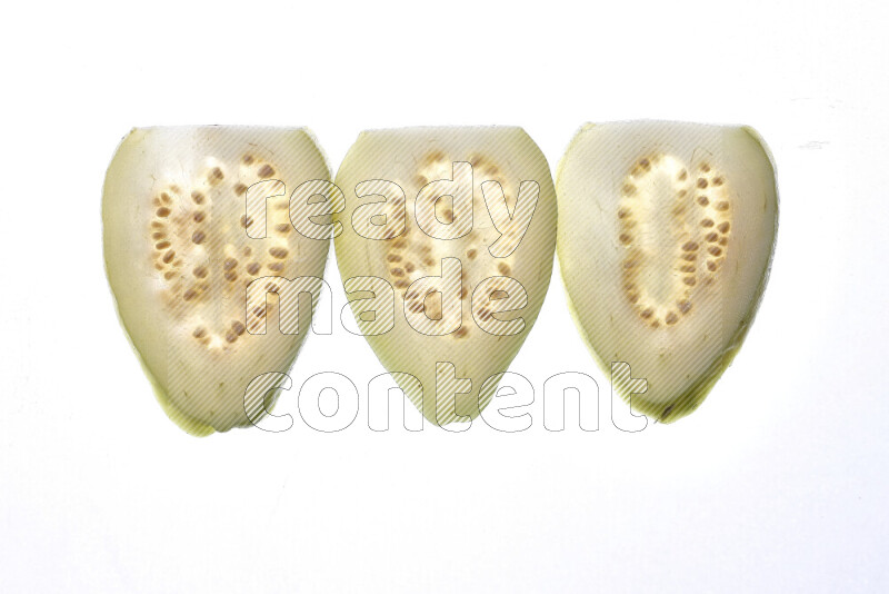 Guava slices on illuminated white background