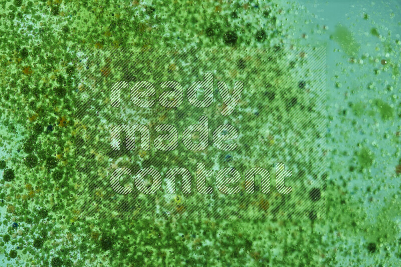 لقطات مقربة لقطرات ألوان مائية خضراء على سطح الزيت على خلفية خضراء