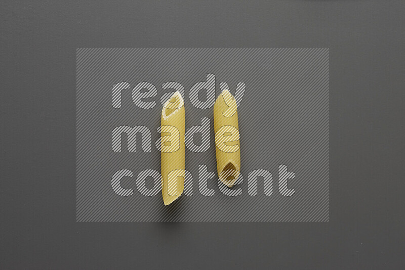 Penne pasta on grey background