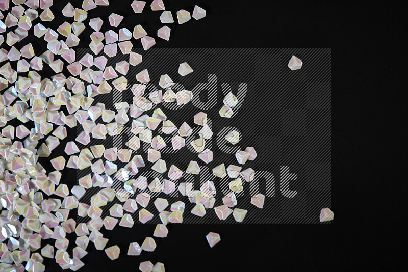 Colorful plastic shards for decoration scattered on a black background