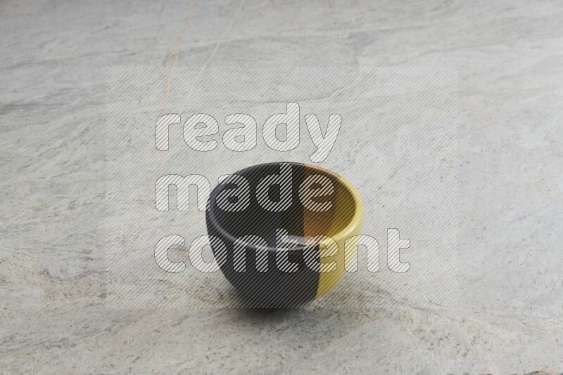 A multicolored pottery bowl on grey marble background