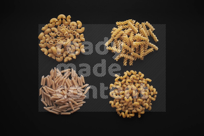 Different pasta types in bunches on black background