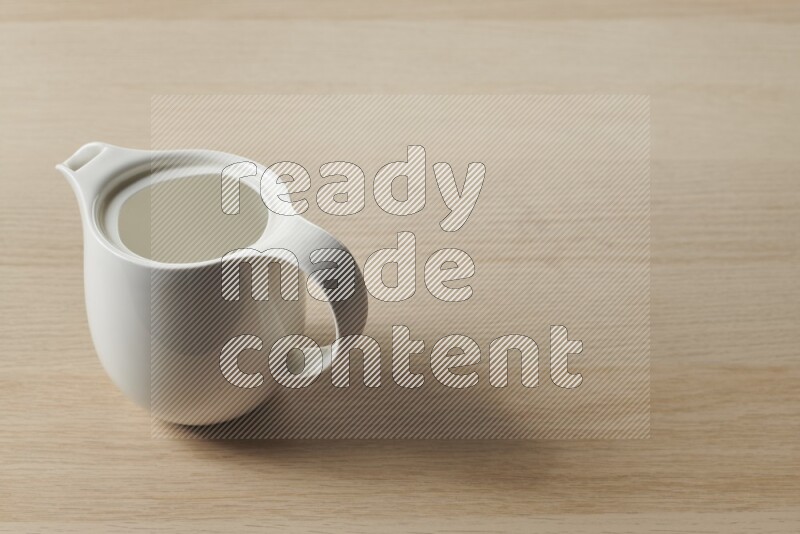A ceramic milk jug on light wooden background