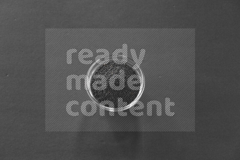 حبة البركة في وعاء زجاجي علي خلفية سوداء