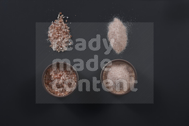 وعاء فخاري ممتلئ بملح الهيمالايا الناعم وملح الهيمالايا الخشن على خلفية سوداء