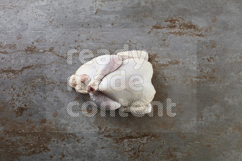 whole raw chicken  direct on a rustic grey background