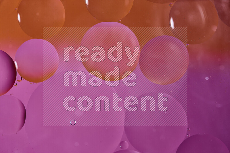 لقطات مقربة لفقاعات من الزيت على سطح الماء باللون البرتقالي والوردي