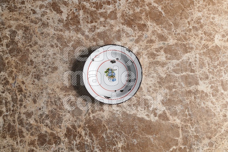 Top View Shot Of A Vintage Metal Plate On beige Marble Flooring