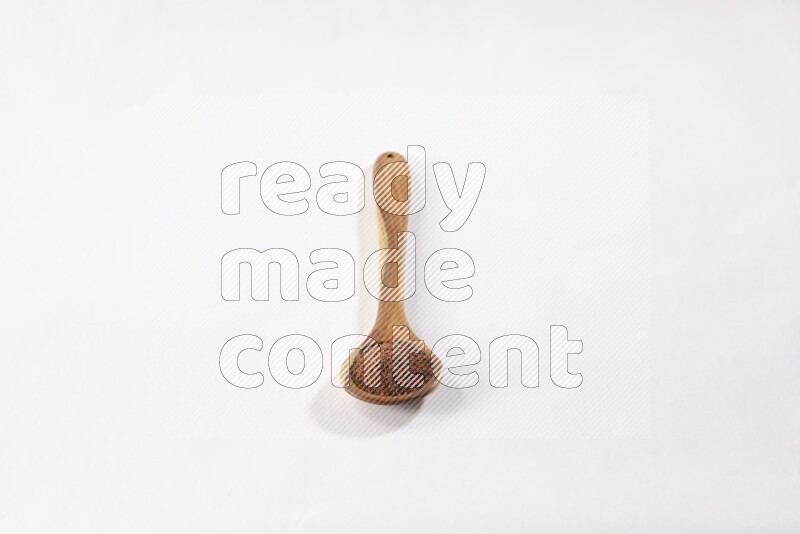 ملعقة خشبية كبيرة ممتلئة ببذور حب الرشاد علي خلفية بيضاء