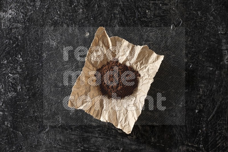بودرة القرنفل في قطعة من الورق على أرضية سوداء