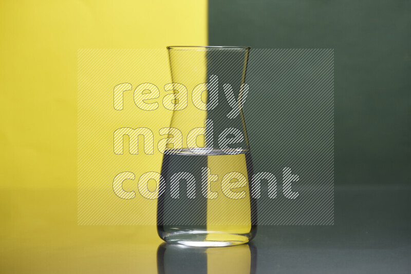 تظهر الصورة أواني زجاجية ممتلئة بالماء موضوعة على خلفية من اللونين الأصفر والأخضر الغامق