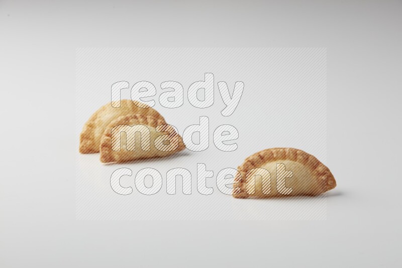 Three fried sambosas on a white background