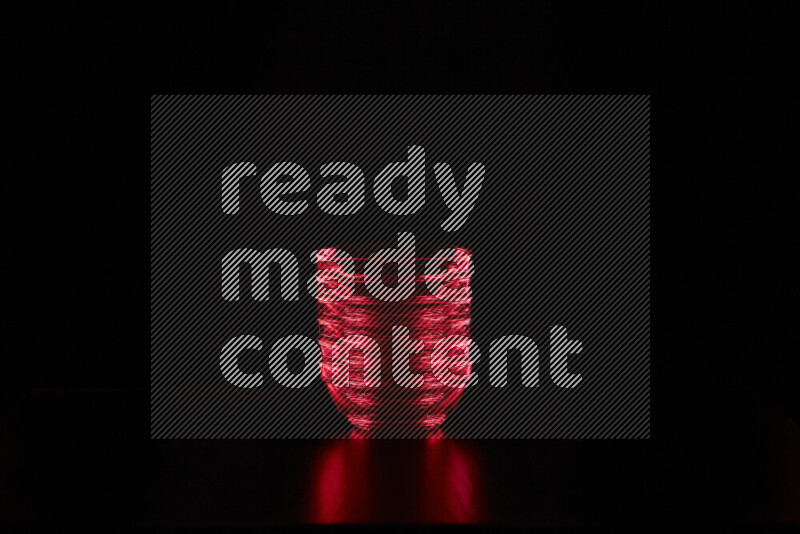 Glassware with rim light in red against black background