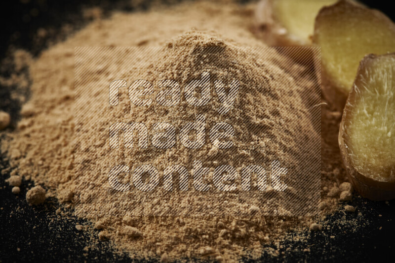 A bunch of ground ginger powder on black background