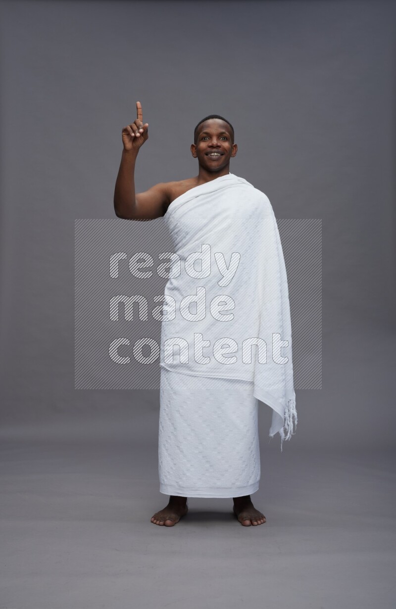 A man wearing Ehram Standing Interacting with the camera on gray background
