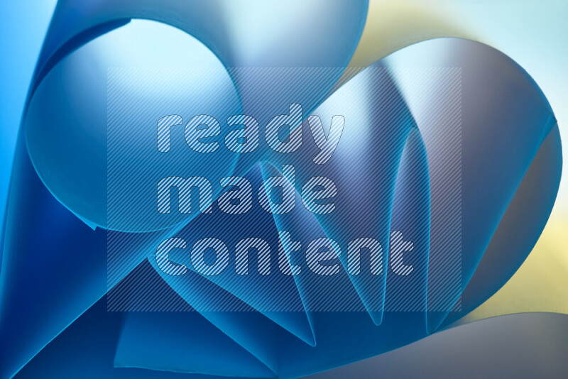 عرض فني لطيات الورق تخلق مزيج من الأشكال الهندسية، مضاءة بإضاءة ناعمة بدرجات اللون الأزرق والالوان الدافئة