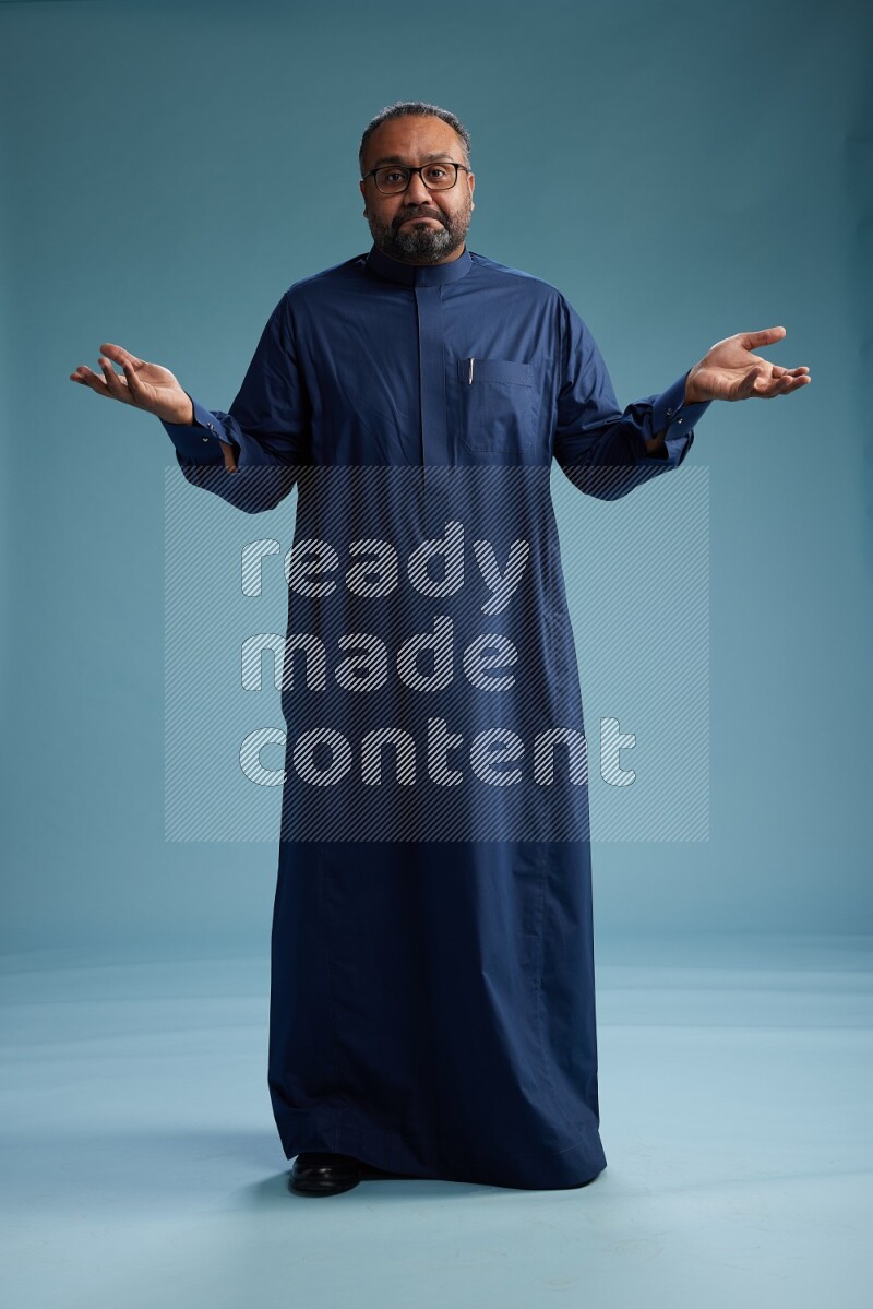 Saudi Man without shimag Standing Interacting with the camera on blue background