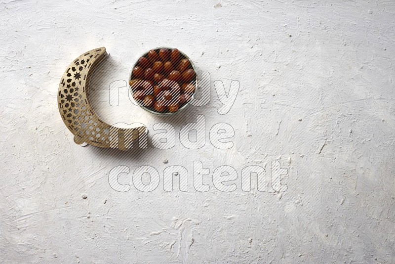 Dates in a pottery bowl with a lantern in a light setup