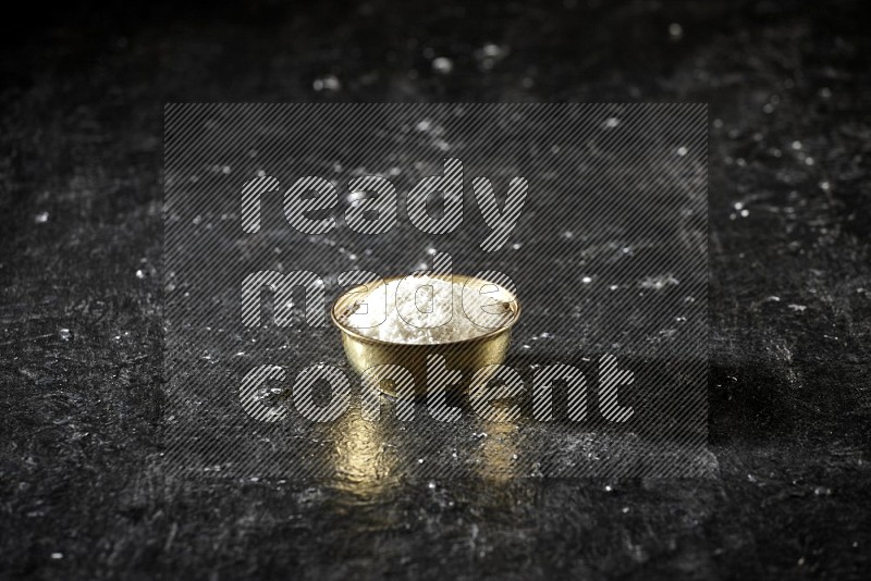 Dried fruits in a metal bowl in a dark setup