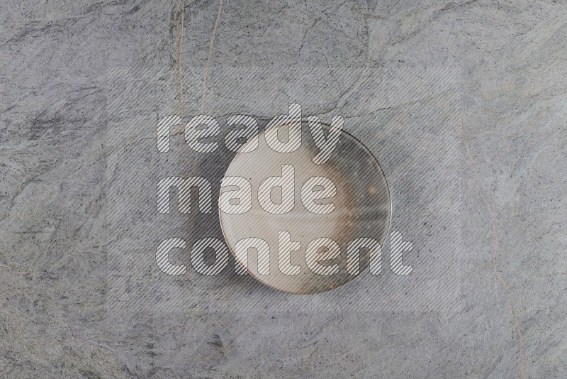 Top View Shot Of A Multicolored Pottery Plate On Grey Marble Flooring