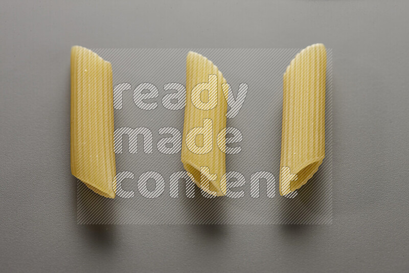 Penne pasta on grey background