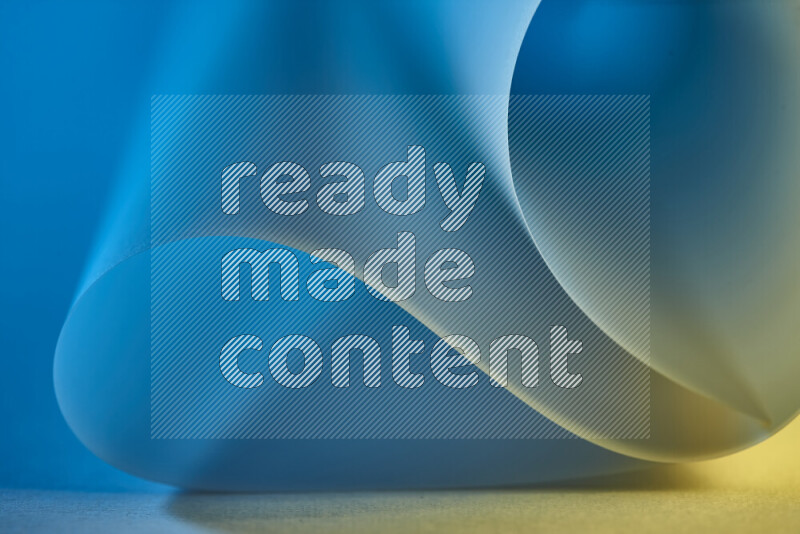 An abstract art piece displaying smooth curves in blue and gold gradients created by colored light