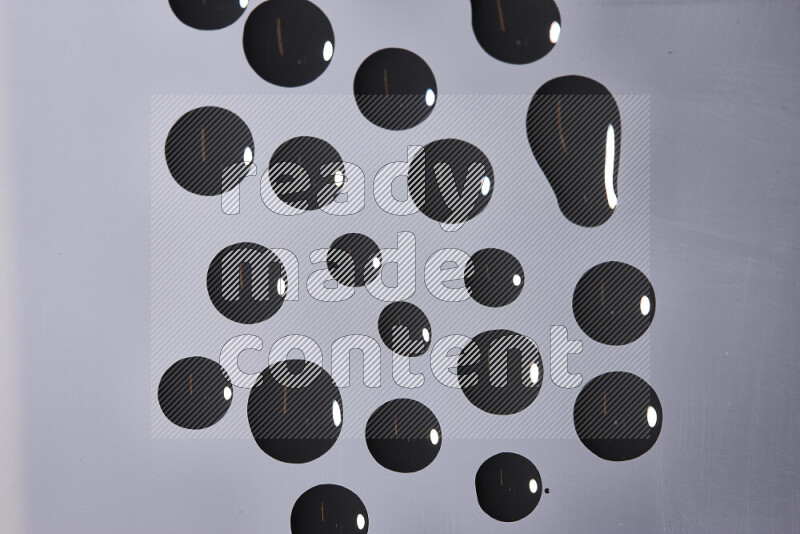 Close-ups of abstract black paint droplets on the surface