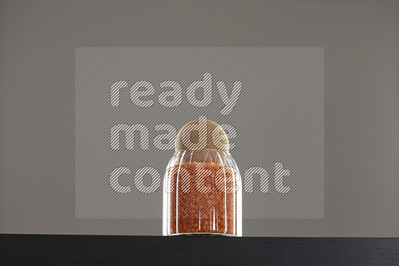 Lentils in a glass jar on black background