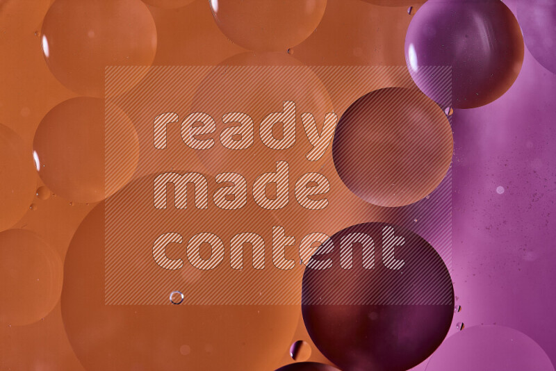 لقطات مقربة لفقاعات من الزيت على سطح الماء باللون البرتقالي والوردي