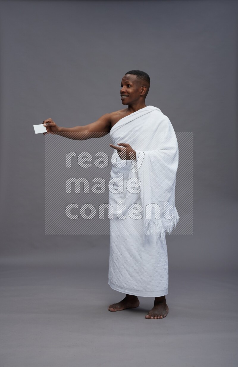 A man wearing Ehram Standing holding ATM card on gray background