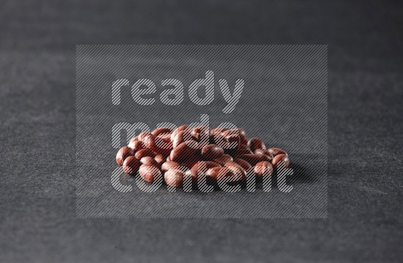 A bunch of red skin peanuts on a black background in different angles