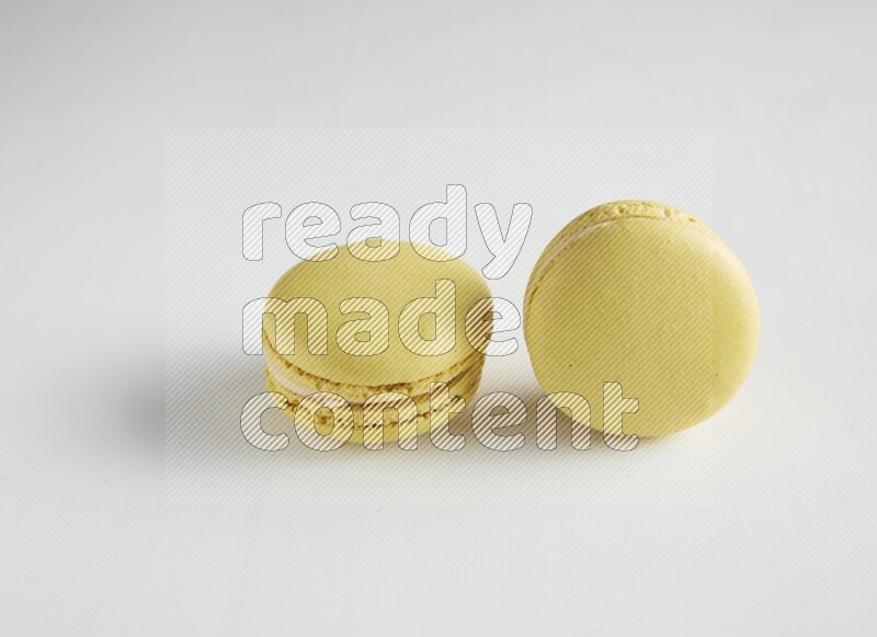 45º Shot of two Yellow Lime macarons on white background