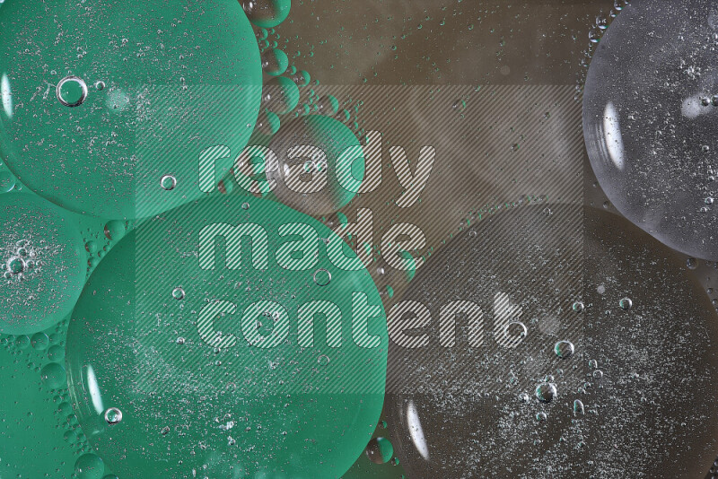 Close-ups of abstract oil bubbles on water surface in shades of green and brown