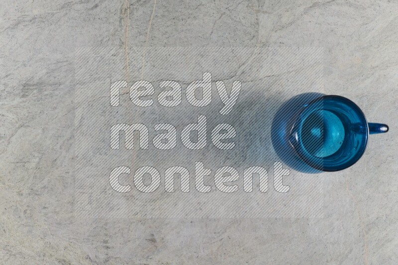 A colored glass jug on grey marble background