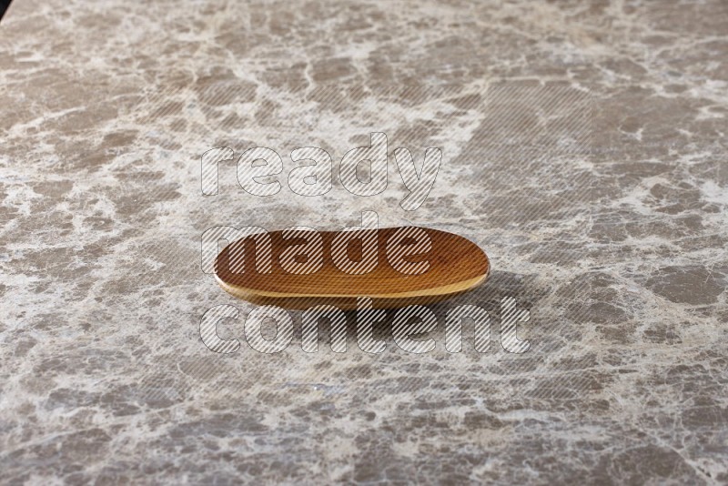 A wooden plate on beige marble background