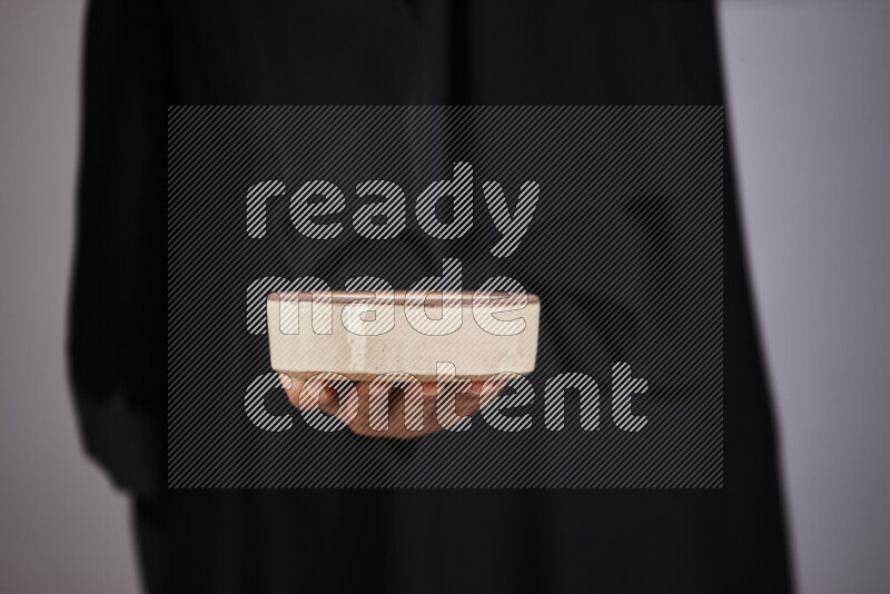 امرأة ترتدي عباءة سوداء تحمل أدوات فخارية مختلفة في أوضاع متعددة