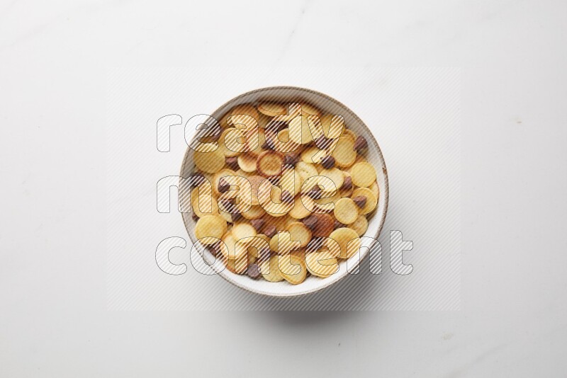 Top-view shot of chocolate chips cereal pancakes in a round bowl on white background